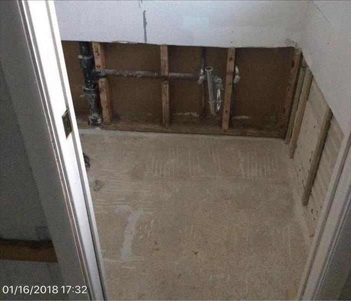 bathroom with no floor, toilet, or sink and flood cuts on walls
