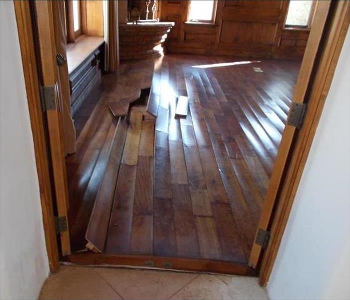 buckled wooden floor boards in a home