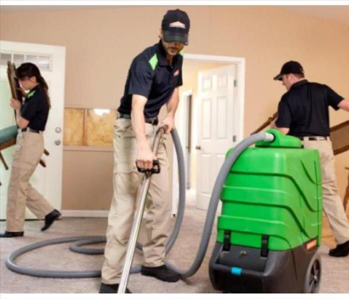SERVPRO employees with restoration equipment in a home