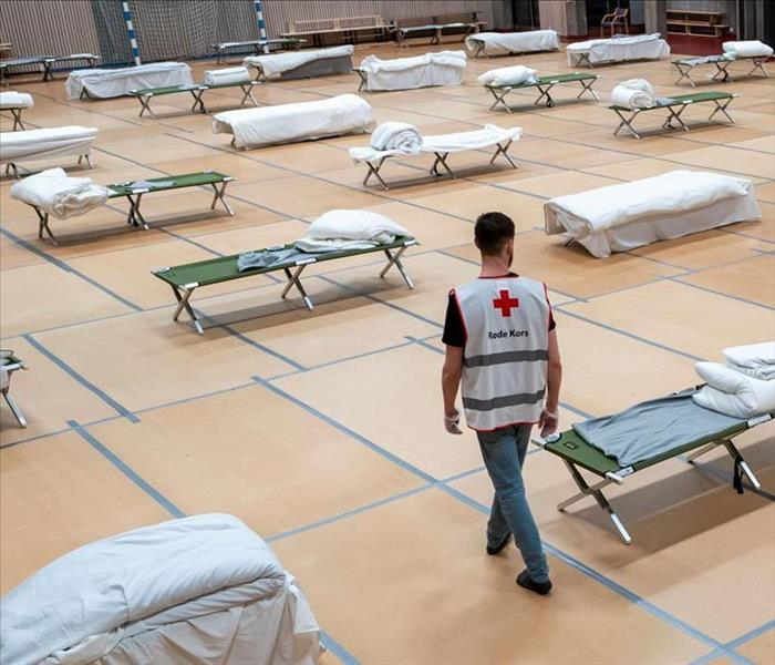 shelter worker examining cots